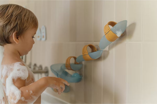 Kind speelt met Little Dutch Waterbaan Blauw in bad, vrolijk badspeelgoed dat stimuleert en waterpret vergroot.