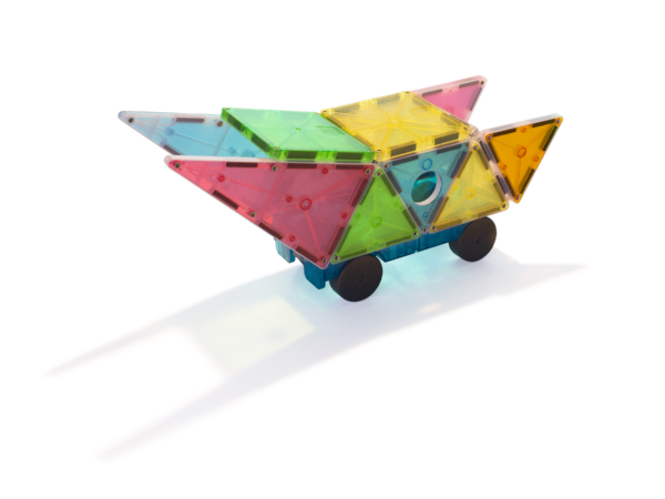 Een MAGNA-TILES Grand Prix-voertuig, gemaakt van doorschijnende tegels en wielen, werpt een schaduw op een wit oppervlak.