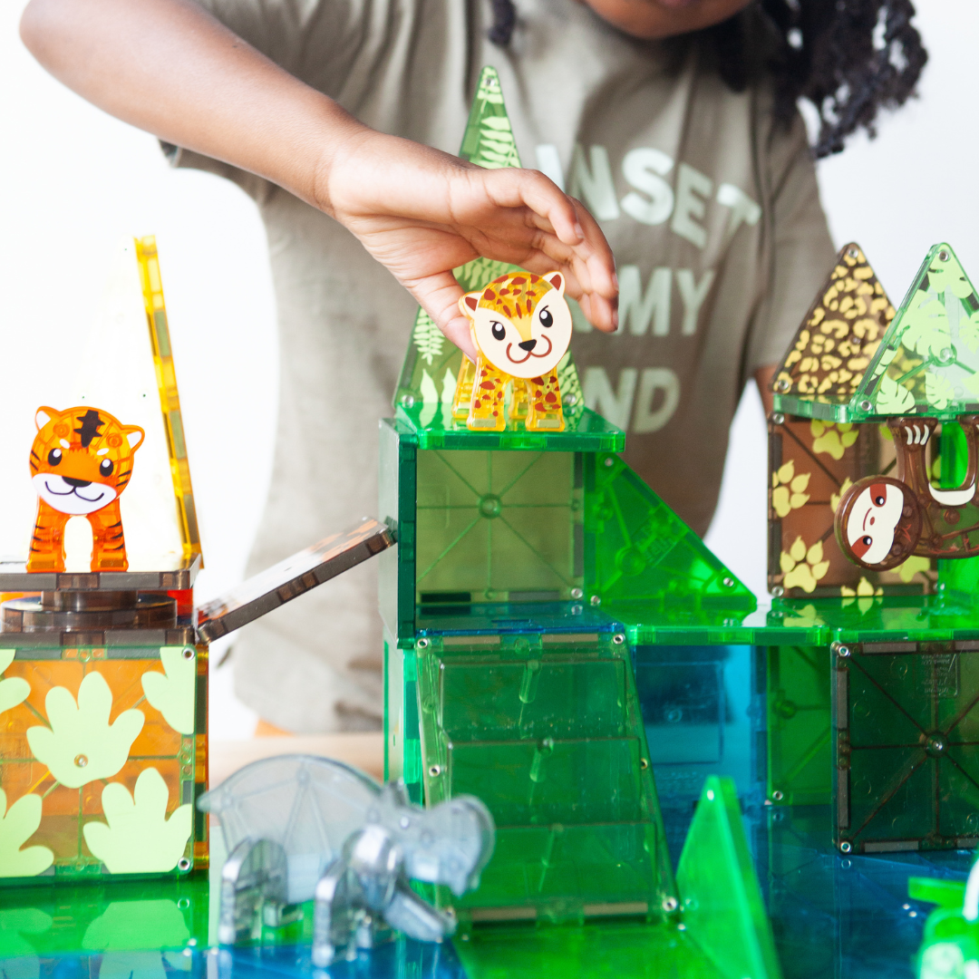 Kind speelt met magnetic magna tiles Jungle Animals, bouwt constructie met luipaard en tijger figuren