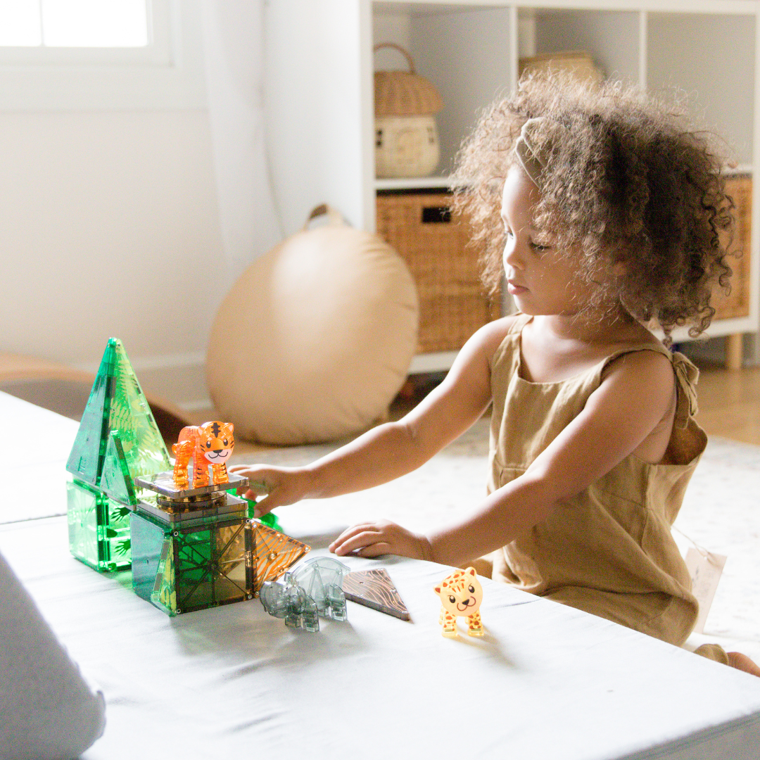 Kind speelt aan tafel met magnetic magna tiles Jungle Animals magnetisch speelgoed in woonkamer sfeer
