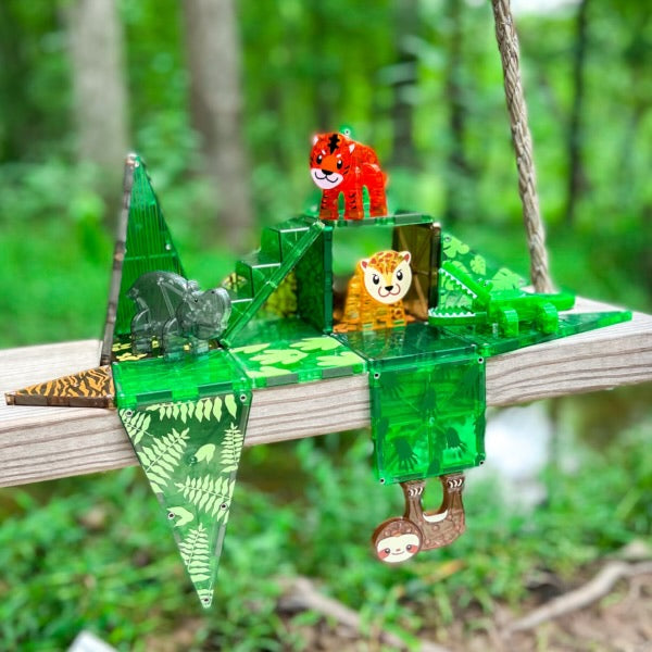 Magna Tiles Jungle Animals - 25 magnetische bouwstenen op een houten plank in een serene groene bosomgeving.