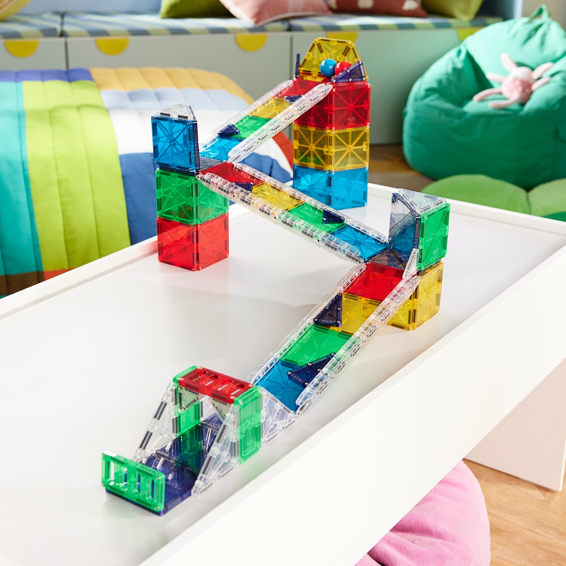 Magnetic magna tiles knikkerbaan magnetisch speelgoed met kleurrijke banen en knikkers op witte tafel