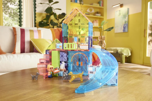 Speelhuis van Magna Tiles Pet Playhouse op tafel met blauwe glijbaan en kleurrijke magnetische bouwstenen.