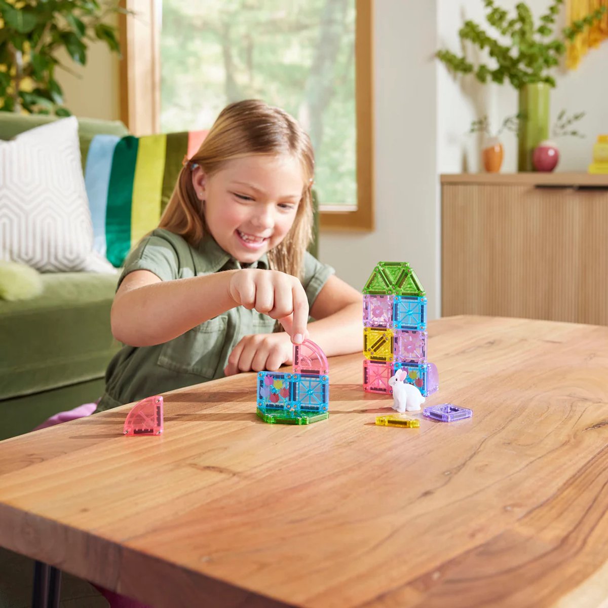 Kind speelt met Magna Tiles travel set, bouwt kleurrijke constructies met 26 magnetische tegels