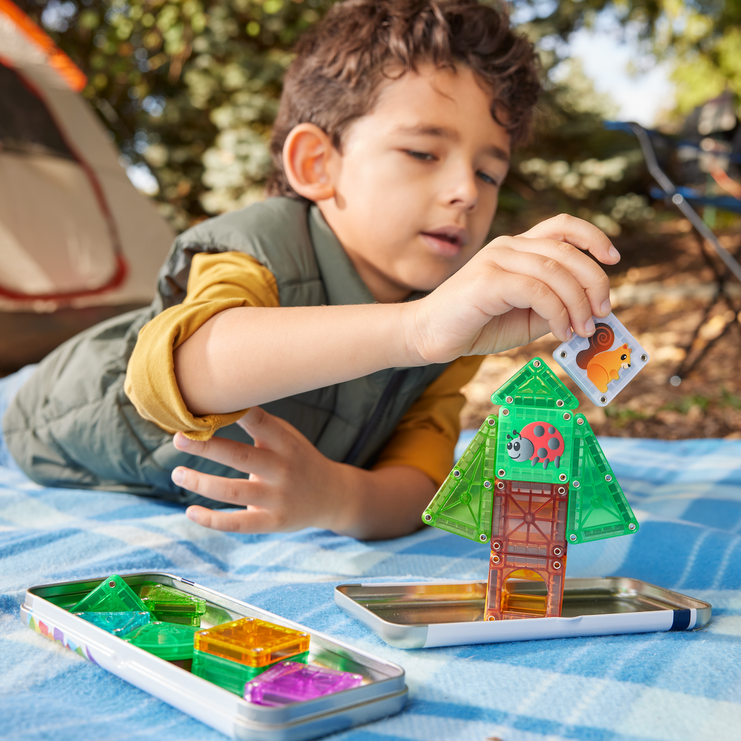 Magna Tiles travel kind bouwt boomhuis met 26 magnetische tegels tijdens outdoor kampeeractiviteit