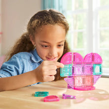 Meisje speelt met Magna Tiles travel set MicroMAGS hartvormige magnetische bouwstenen in roze