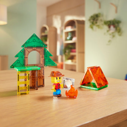 Magne Tiles Camp Out magnetisch speelgoed met boomhut, tent en ontdekker figuurtje op houten tafel