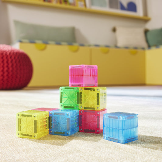 Magne Tiles MicroMags magnetische blokken bouwset in geel, roze, blauw en groen op speelkleed kinderkamer
