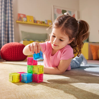 Magneet blokken MicroMags voor peuters, meisje bouwt toren met gekleurde magnetische bouwstenen