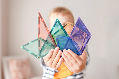 Kind houdt kleurrijke magneet tegels vast uit de Connetix Pastel Shape Expansion Pack 48pc, detailfoto