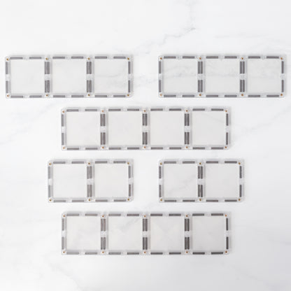 Bovenaanzicht alle 12 Connetix Clear Rectangle magnetische tegels plat uitgelegd marmeren witte ondergrond