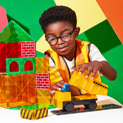 Kind bouwt met magnetic magna tiles Builder XL, gele kiepwagen en kleurrijke magnetische tegels