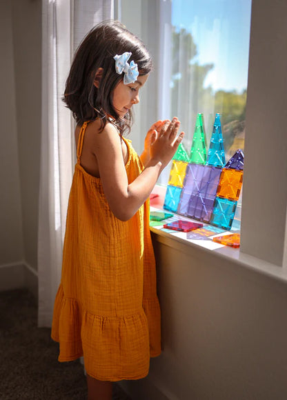 Meisje speelt bij het raam met Magnetic Magna Tiles Classic Set, 32 kleurrijke magnetische bouwstenen magneet speelgoed.