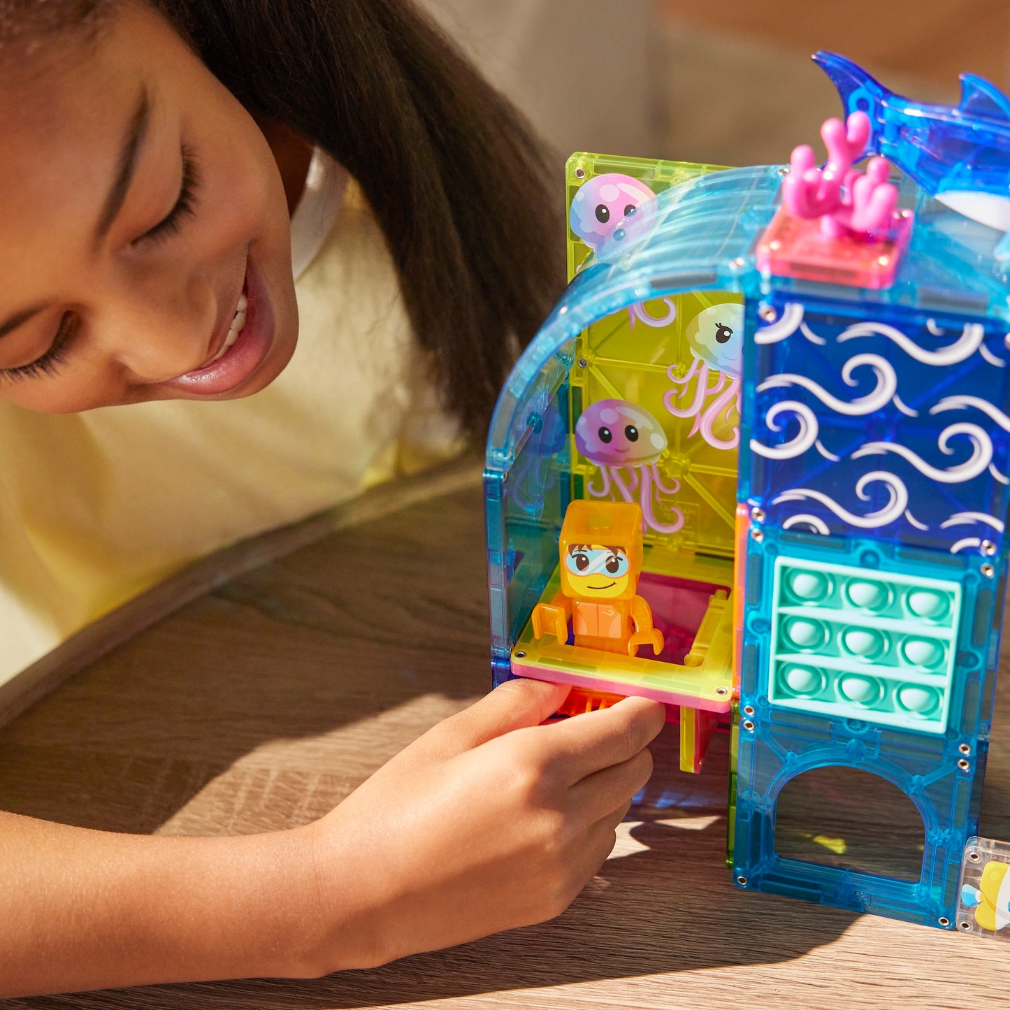 Magnetic magna tiles detail close-up kind speelt met sensorisch speelgoed en pop it fidget toy