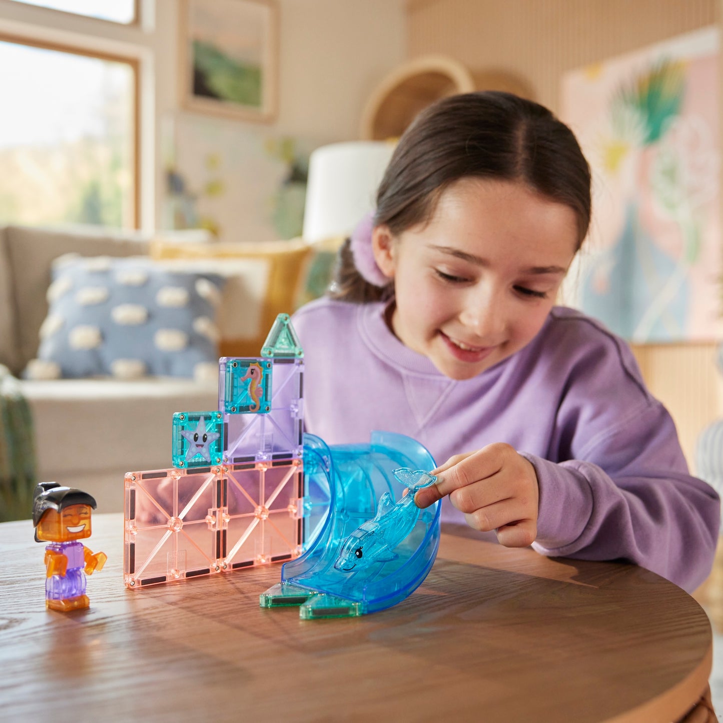 Kind speelt met Magnetic magna tiles Dolphin Bay magnetische dolfijn en glijbaan op houten tafel