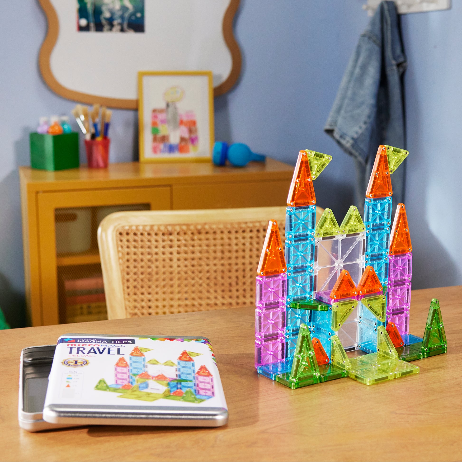 Magnetic magna tiles kasteel op kinderkamer tafel naast Travel Set Deluxe opbergdoos met magneten