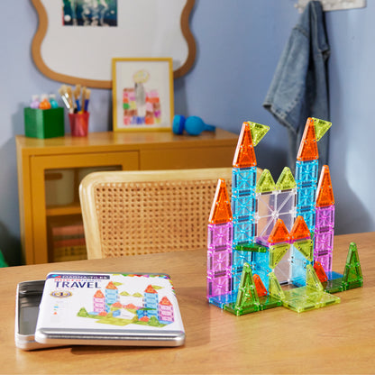 Magnetic magna tiles kasteel op kinderkamer tafel naast Travel Set Deluxe opbergdoos met magneten