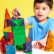 Kind speelt met magnetic magna tiles combo magnetisch speelgoed in kleurrijke vormen op gele achtergrond