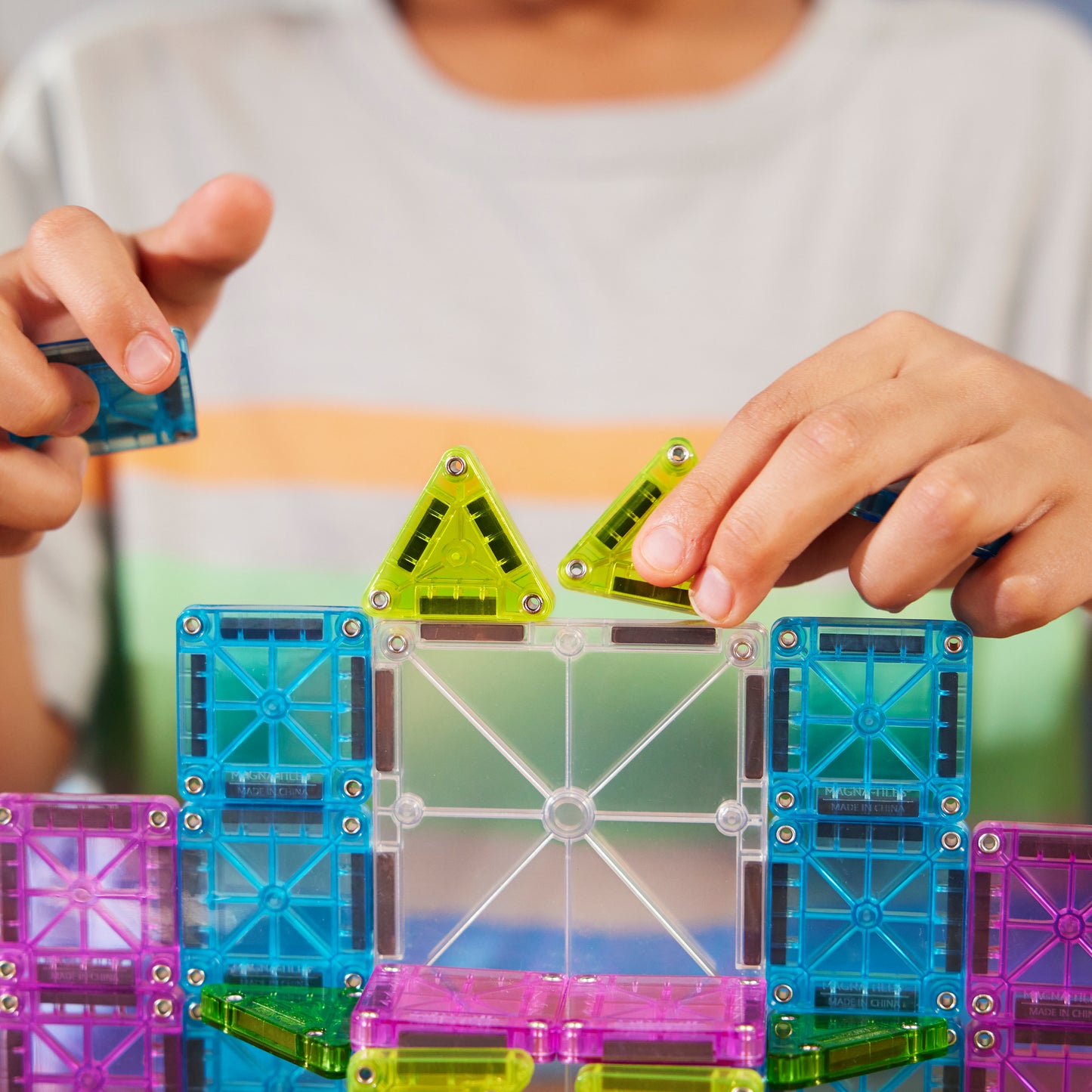 Magnetic magna tiles detail foto kinderhanden bouwen met MicroMags vierkante en driehoekige tegels