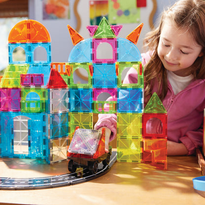 Magnetic magna tiles speelsituatie met meisje dat kleurrijk magnetisch speelgoed stadgebouw bouwt