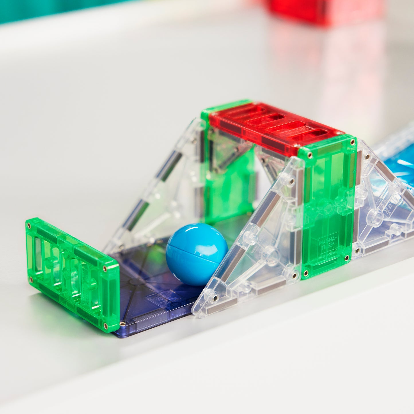 Magnetic magna tiles MicroMags detail foto van groene en rode magnetische tegels met blauwe knikker