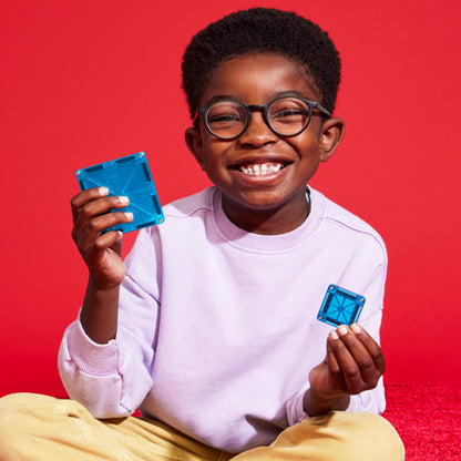 Magnetic magna tiles MicroMags speelgoed, blij kind met blauwe magneet tegels in beide handen