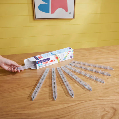 Magnetic magna tiles Rail Pack met 8 magnetische rails uitgespreid op tafel naast verpakking