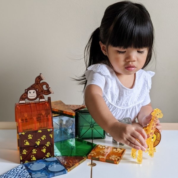 Kind speelt enthousiast met Magnetic Magna Tiles Safari Animals set met leeuw, 25 magnetische bouwstenen magneet speelgoed.