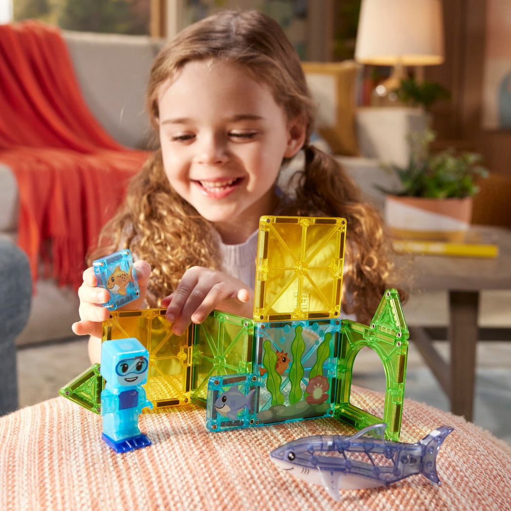 Meisje speelt met Magnetic magna tiles Shark Dive magnetisch speelgoed met onderwaterthema en haai