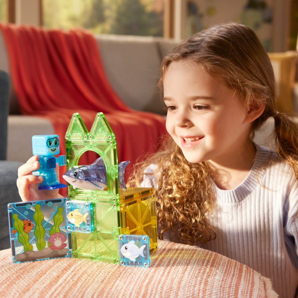 Meisje bouwt met Magnetic magna tiles Shark Dive magneet speelgoed met onderwaterwereld en haaifiguur