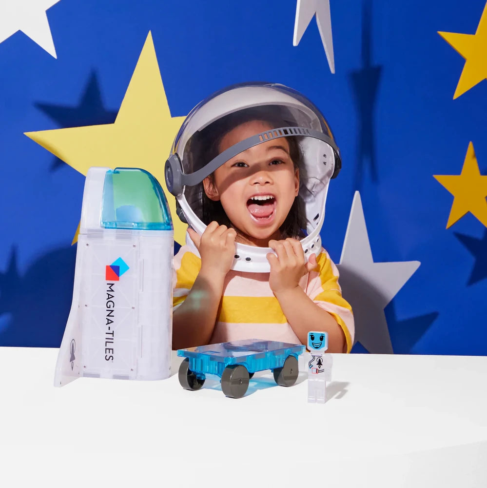Kind speelt enthousiast met Magnetic Magna Tiles Space set en ruimtehelm, inclusief MicroMags figuurtje en magneet speelgoed.