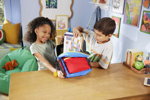 Twee kinderen stoppen de compacte Magna Tiles Travel Set in hun rugzak, ideaal voor onderweg en vakantie.