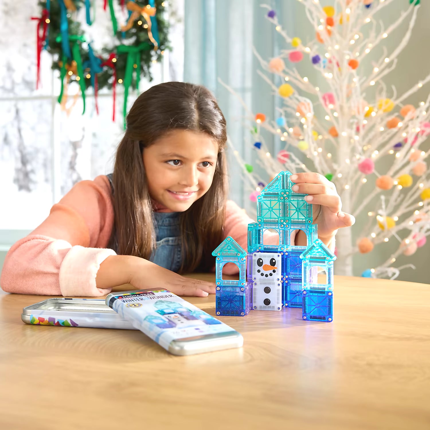 Kind speelt binnen met Magnetic Magna Tiles Winter Wonder Travel Set, kleurrijk magnetisch speelgoed ideaal als kerstcadeau.