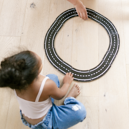 Magnetic magna tiles XTRAS roads bovenaanzicht kind bouwt racecircuit met 12 magnetische tegels op vloer
