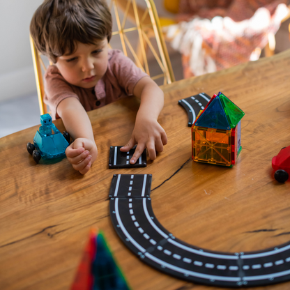 Magnetic magna tiles XTRAS roads kind speelt met magnetisch speelgoed en kleurrijk huisje op houten tafel
