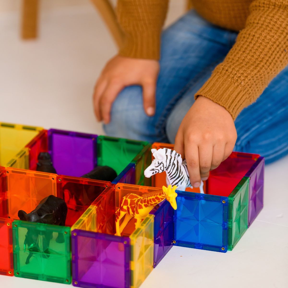 Magnetisch speelgoed Coblo kind speelt met kleurrijke tegels en speelgoeddieren binnen