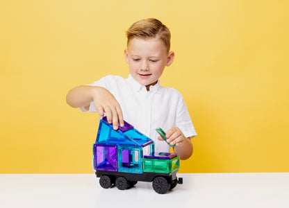 Kind bouwt vrachtwagen met Connetix Transport Bright Pack 50 magnetisch speelgoed op gele achtergrond