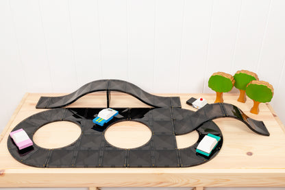 Magnetisch speelgoed Connetix racebaan met zwarte tegels en gekleurde speelgoedauto's bovenaanzicht