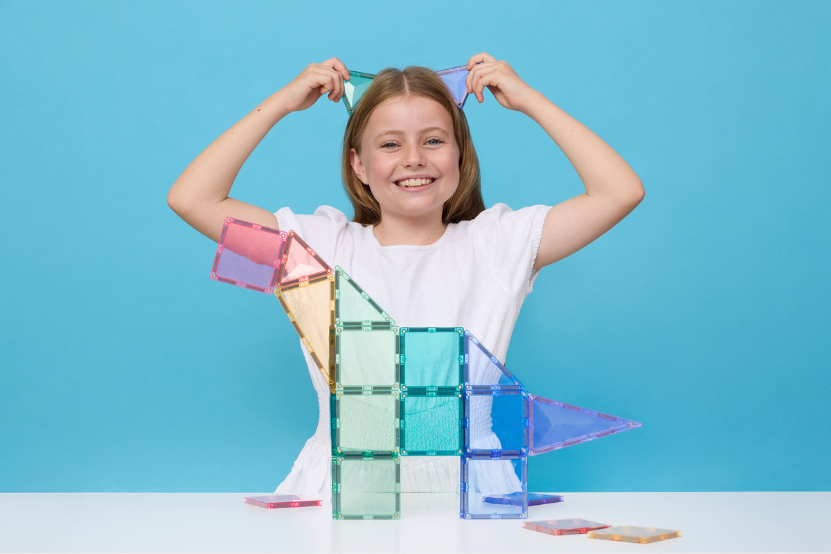 Kind speelt met Connetix Pastel magnetisch speelgoed vierkante en driehoekige magneet tegels