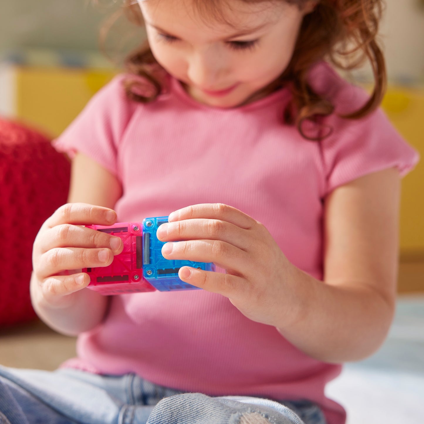 Magnetisch speelgoed MicroMags voor peuters, kind verbindt roze en blauwe magneetblokjes
