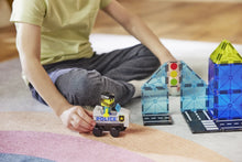 Kind bestuurt MicroMags politiewagen met magneet speelgoed en blauw-geel Police Patrol gebouw van Magna Tiles.