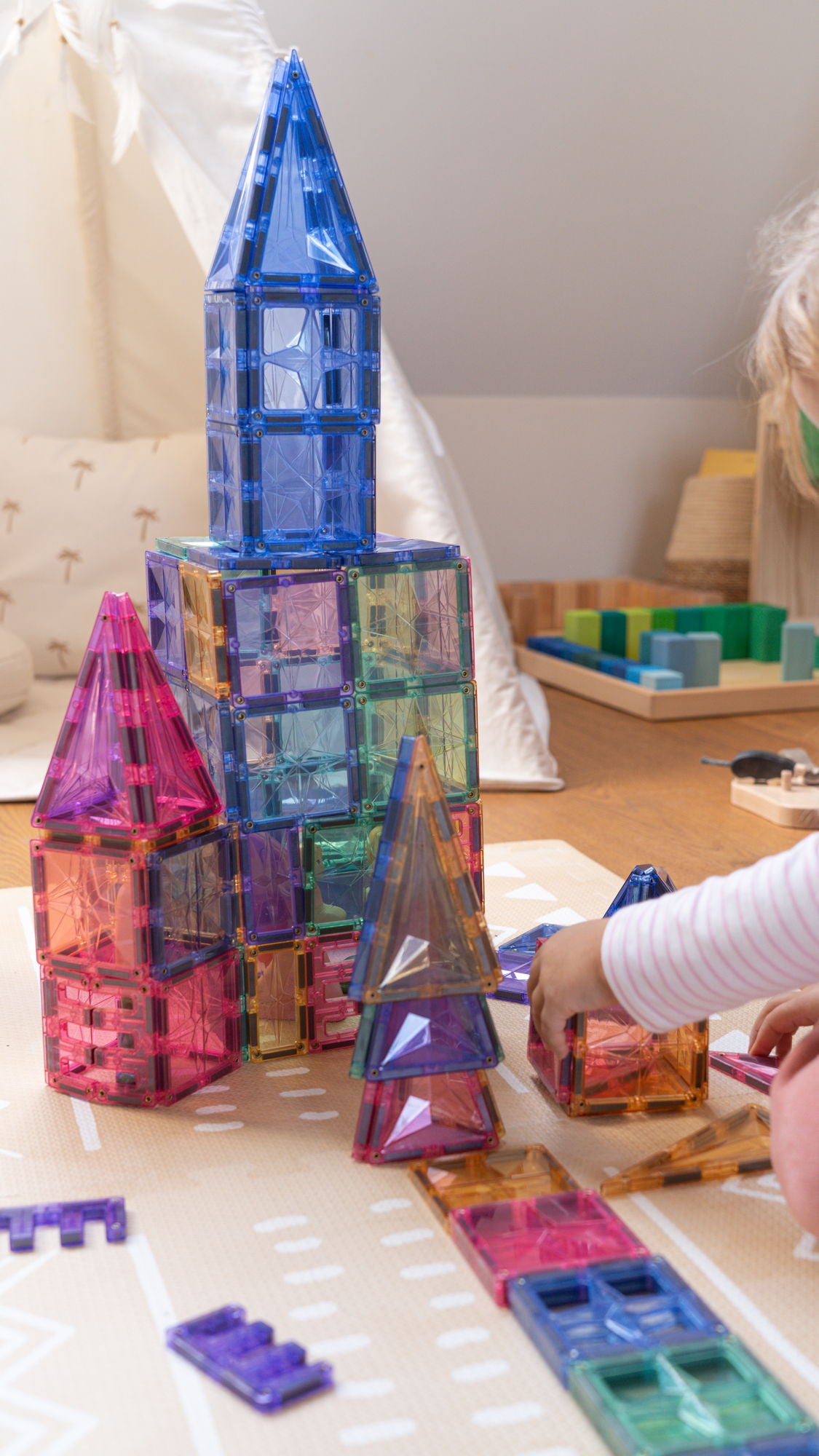 Magnetisch speelgoed raket, kind bouwt hoge toren met Coblo speelgoed magneten in pastelkleuren thuis