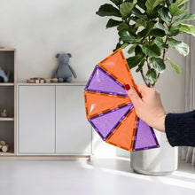 Magnetische glitter tegels Coblo in paars en oranje vastgehouden in kinderkamer met plant