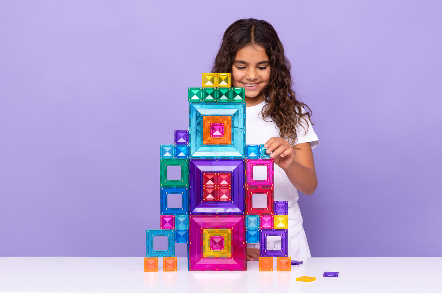 Meisje bouwt hoge toren met Connetix Bright Portal Pack 48pc magnetische bouwstenen in felle kleuren