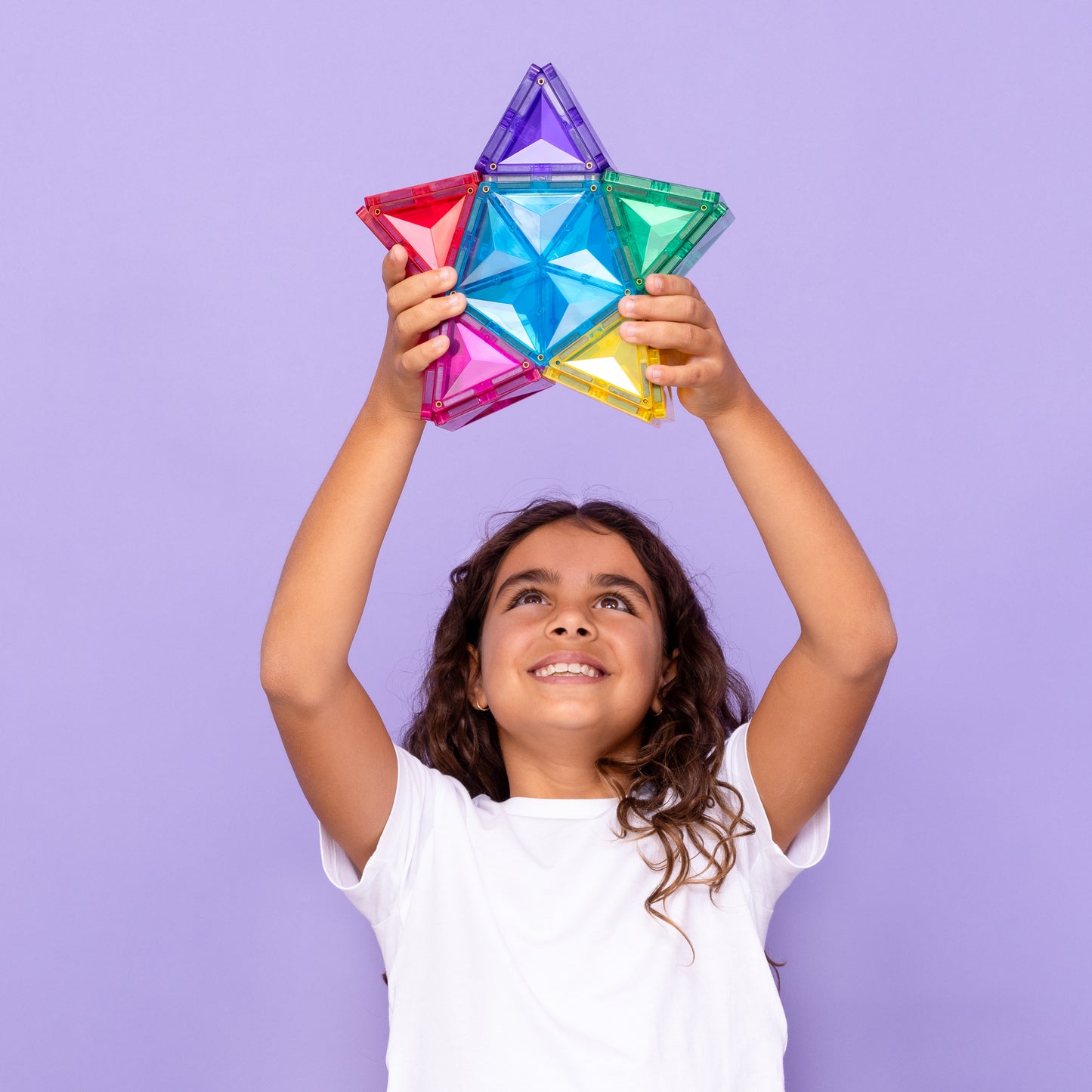 Meisje toont magnetisch speelgoed Connetix ster omhoog, gekleurde magneten speelgoed voor kinderen 3+