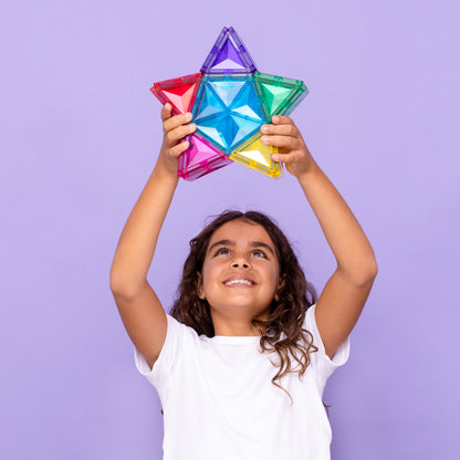 Meisje toont magnetisch speelgoed Connetix ster omhoog, gekleurde magneten speelgoed voor kinderen 3+
