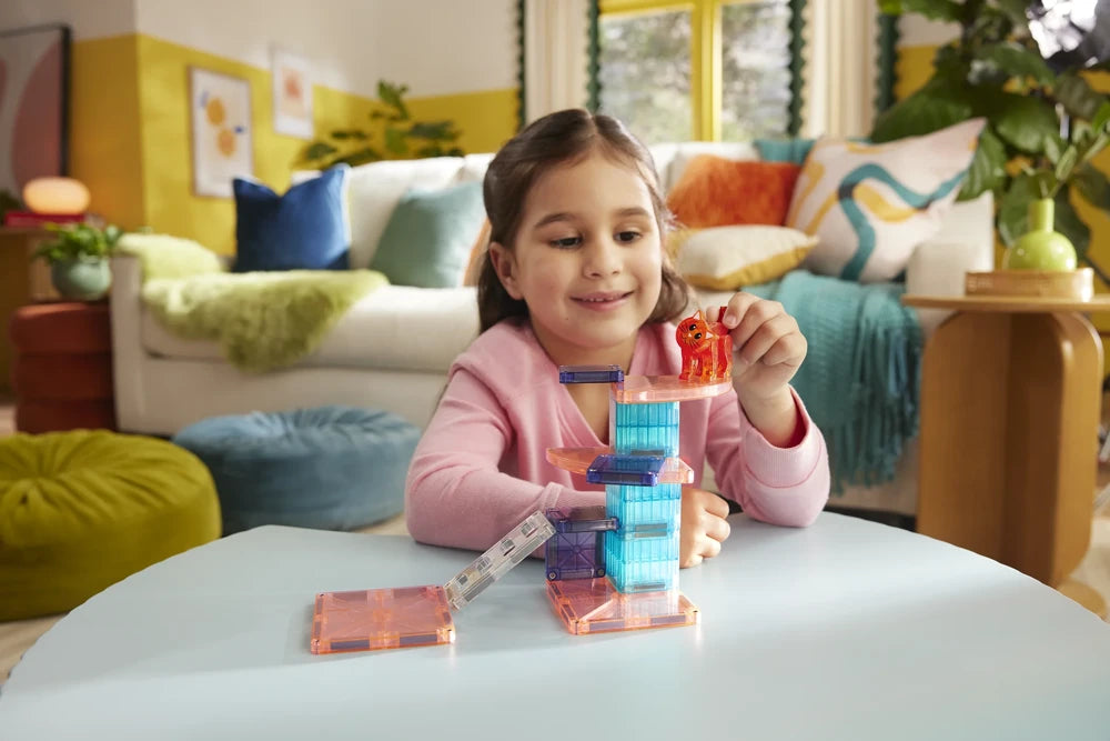 Meisje speelt aan tafel met de Magna Tiles Cat Tree set met magnetische tegels en rode kat.