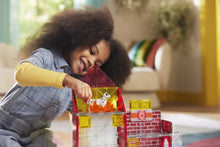 Meisje zet dalmatiër in magnetisch gebouw van Fire Station, gemaakt van kleurrijke magnetische tegels.