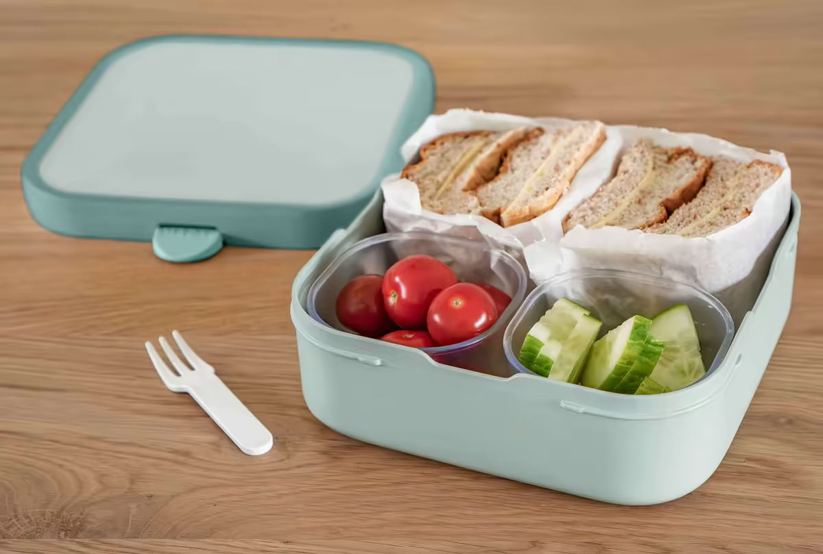 Groene Mepal lunchbox voor kinderen met bento-indeling, gevuld met brood, tomaten en komkommer, kindvriendelijk ontwerp.