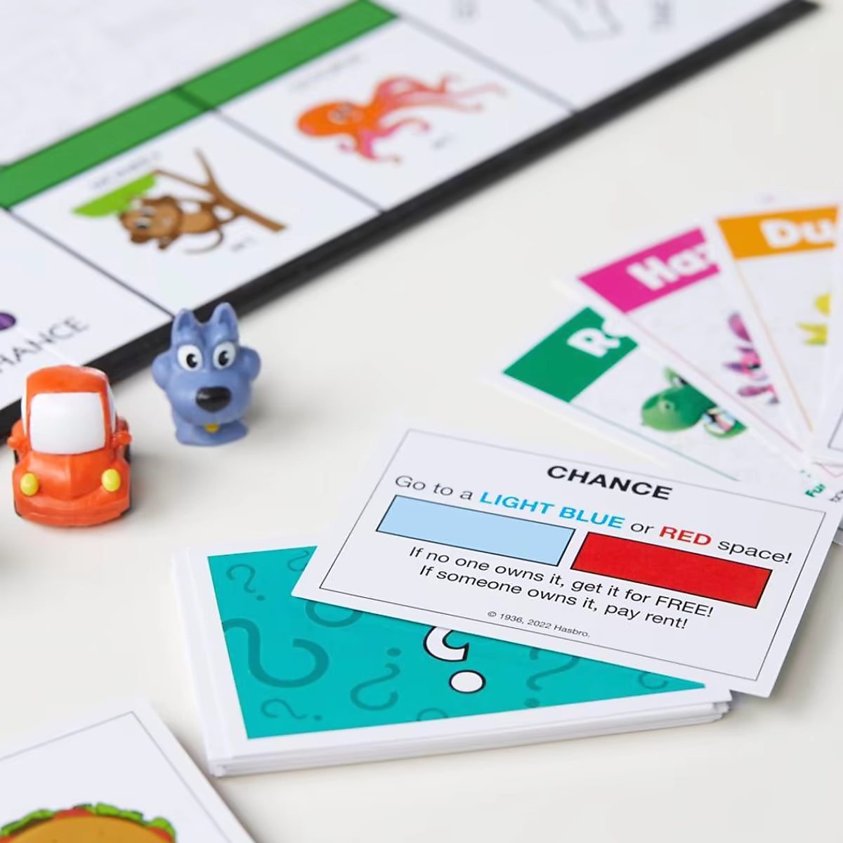 Monopoly Junior detailfoto van speelkaarten, pionnen zoals auto en Woef hond, leerzaam Hasbro bordspel voor kinderen.